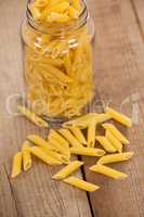 Pennette pasta spilled out of glass jar