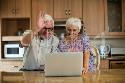Senior couple using laptop in the kitchen
