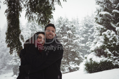 Couple embracing in forest during winter