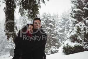 Couple embracing in forest during winter