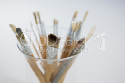 Close-up of various paintbrush in a glass jar