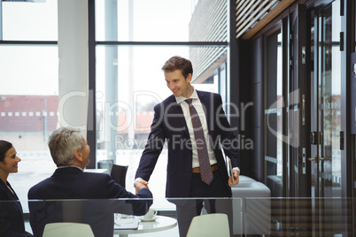 Businesspeople shaking hands in a lobby