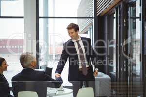 Businesspeople shaking hands in a lobby