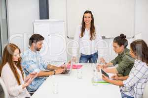 Attentive executive using laptop and digital tablet in conference room