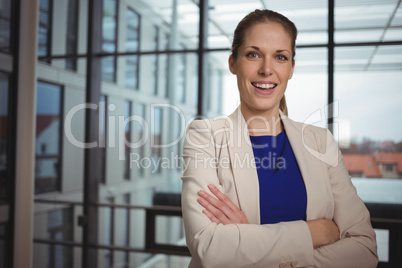 Portrait of beautiful businesswoman standing with arms crossed in corridor Portrait of beautiful businesswoman standing with arms crossed in corridor