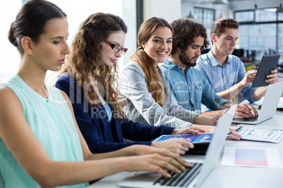 Business team working on laptop and digital tablet in meeting