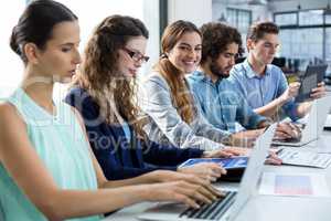 Business team working on laptop and digital tablet in meeting