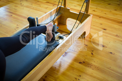 Woman practicing stretching exercise on reformer