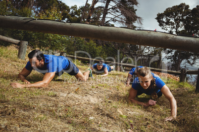 Fit people crawling under the net during obstacle course