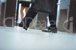 Businessman with briefcase walking in the office