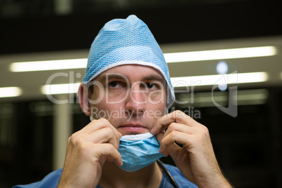 Thoughtful male surgeon wearing surgical mask