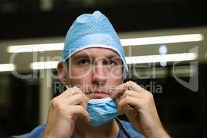 Thoughtful male surgeon wearing surgical mask