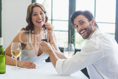 Man proposing a woman with a ring in the restaurant