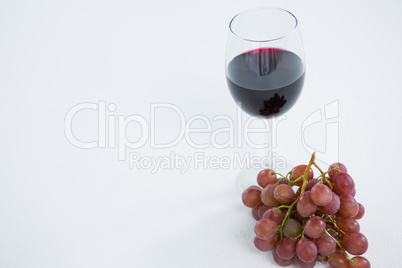 Close-up of red bunch of grapes with glass of red wine