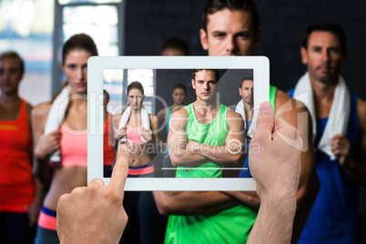 Composite image of hand holding tablet pc