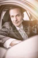 Smiling businessman sitting in car