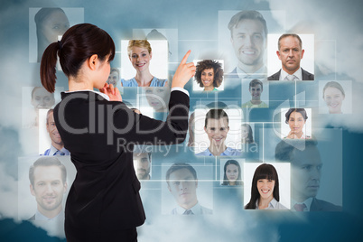 Composite image of thoughtful businesswoman pointing