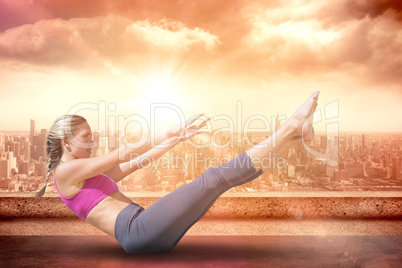Composite image of focused fit blonde doing yoga on the beach
