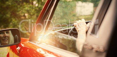 Cheerful mature woman driving convertible
