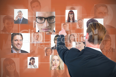 Composite image of rear view of young businessman in suit pointing