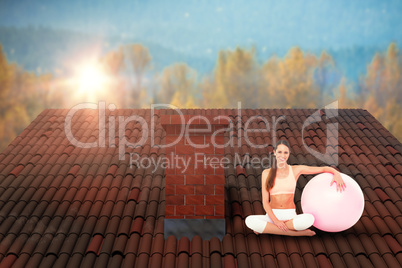 Composite image of smiling fit young woman sitting with fitness ball