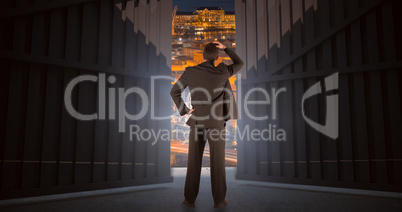Composite image of businessman standing back to the camera with hand on head 3d