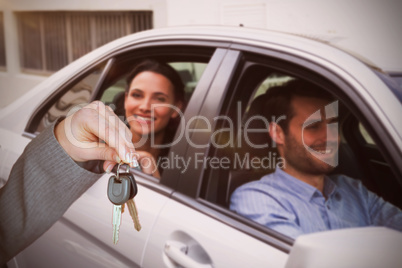 Composite image of person handing keys to someone else