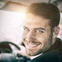 Man sitting in a car and holding a smartphone smiling at camera