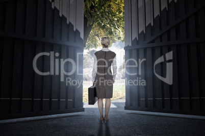 Composite image of back turned businesswoman holding a briefcase 3d