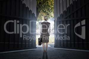 Composite image of back turned businesswoman holding a briefcase 3d