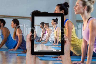 Composite image of close-up of hands holding digital tablet