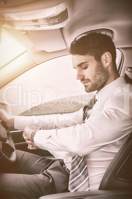 Businessman checking time while sitting on drivers seat