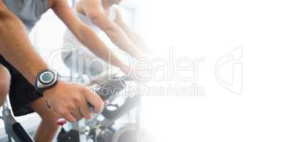 Midsection of men working on exercise bikes