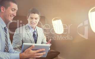 Composite image of businessmen working together with laptop and tablet