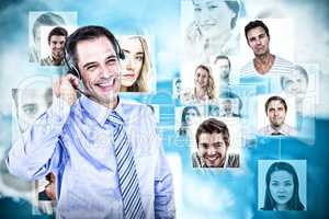 Composite image of smiling businessman using headset