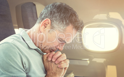 Composite image of tensed man standing against window