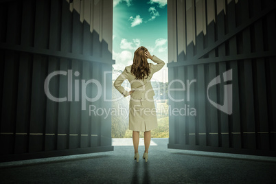 Composite image of businesswoman standing back to camera with hand on head 3d