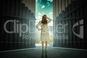Composite image of businesswoman standing back to camera with hand on head 3d