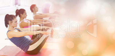 Class stretching on mats at yoga class in fitness studio