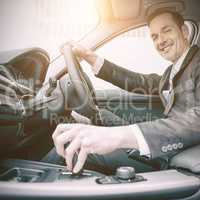 Man driving a car and smiling at camera