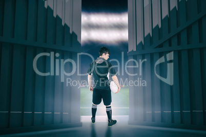 Composite image of back turned rugby player holding a ball 3d