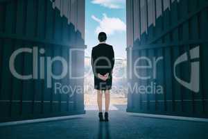 Composite image of young businesswoman standing with hands behind back 3d