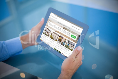 Composite image of businessman using his tablet