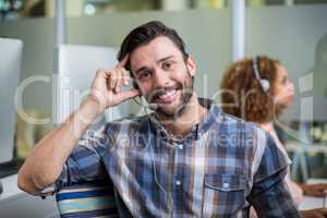 Portrait of male customer service executive talking on headset at desk