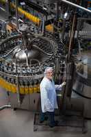 Factory engineer monitoring filled juice bottle on production line