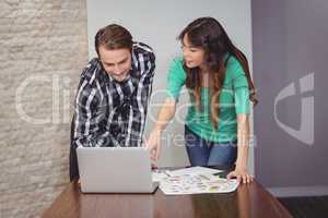 Male and graphic designers discussing over laptop