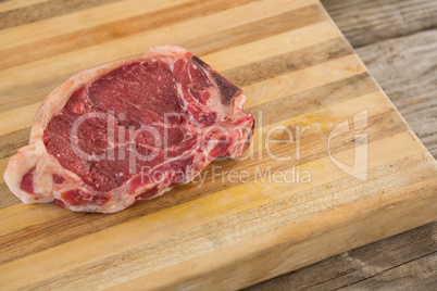 Sirloin chop on wooden tray against wooden background