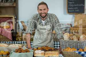 Portrait of smiling male staff standing at counter