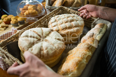 Male staff holding a basket of bread