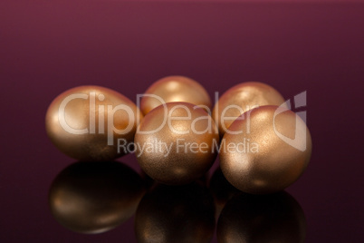 Golden Easter eggs on colored background
